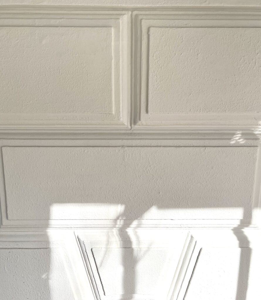 Detailaufnahme der Fassadensanierung, weiß gestrichen, Stuckornamente